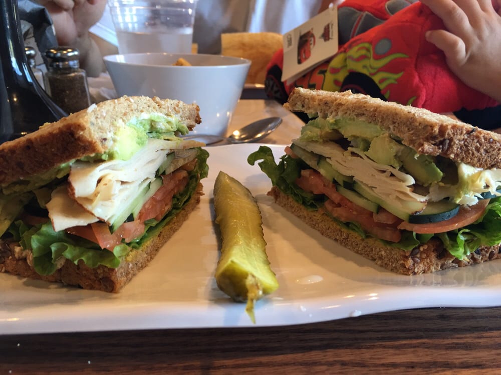 Turkey avocado sandwich with a side pickle
